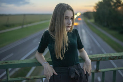 Woman in shoe stands leaning on a bridge