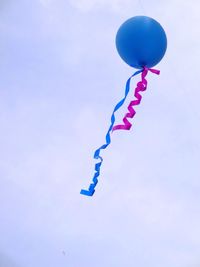 Low angle view of balloons against blue sky