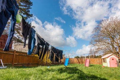 Clothes drying on field by building against sky