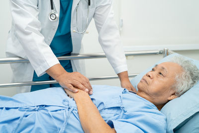 Holding hands asian senior or elderly old lady woman patient with love, care, encourage and empathy 