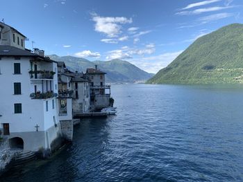 Buildings by sea against sky