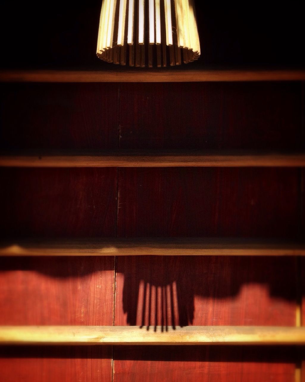 indoors, illuminated, wood - material, pattern, home interior, in a row, close-up, no people, shadow, sunlight, still life, absence, night, table, lighting equipment, wall - building feature, red, hanging, focus on foreground, dark