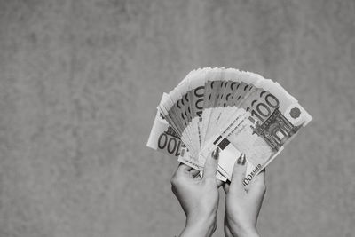 Low section of woman holding paper currency