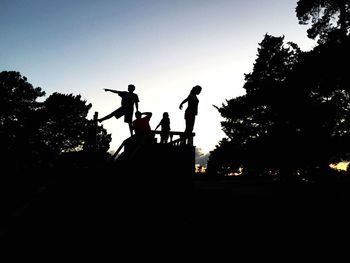 Low angle view of silhouette statues against sky