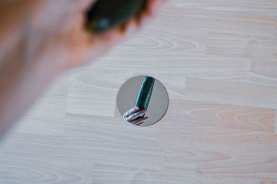 High angle view of hand holding ball on table