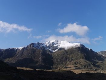 Scenic view of snowcapped mountains against blue sky