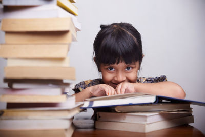 Portrait of boy sitting on book