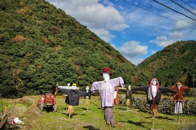 Scarecrow on field against sky