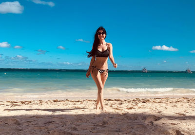 Rear view of young woman standing at beach