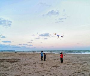 People at beach against sky