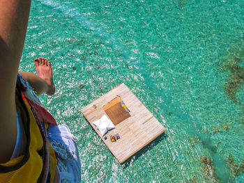 Low section of woman paragliding over sea