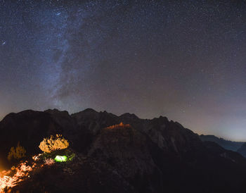 Scenic view of illuminated mountains against sky at night