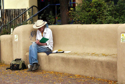 Full length of a young man sitting outdoors