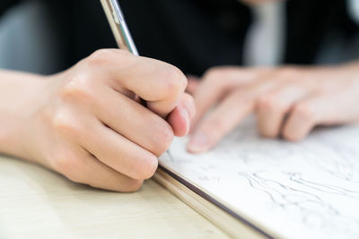 Midsection of woman drawing in book