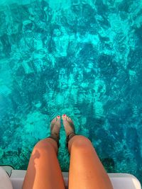Low section of woman legs in swimming pool