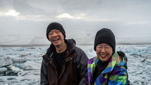 Portrait of smiling young woman in sea during winter