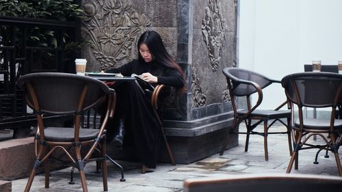 Woman reading menu while sitting at cafe
