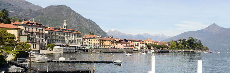 Buildings by sea against sky