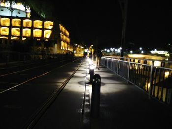 Person walking on illuminated street at night