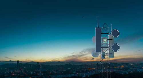 Low angle view of illuminated buildings against sky at sunset