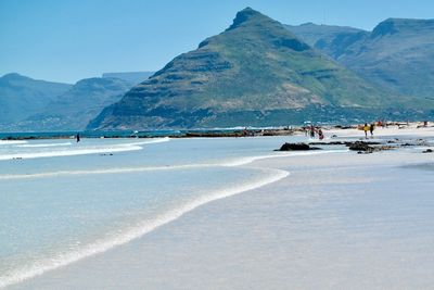 Scenic view of beach and mountains against sky