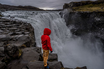 Rear view of man in waterfall