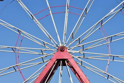 Low angle view of ferris wheel against clear blue sky