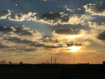 Scenic view of silhouette field against sky at sunset