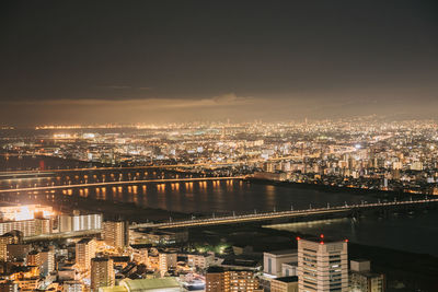 High angle view of illuminated buildings against sky at night