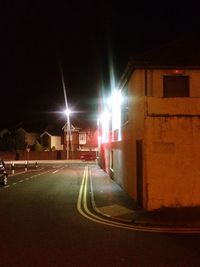 Illuminated street light on road at night