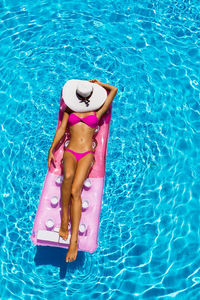 Young woman floating in swimming pool