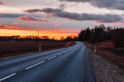 Country road against sky during sunset