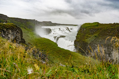 Scenic view of waterfall against sky