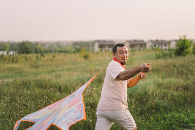 Happy family and children run on meadow with a kite in the summer on the nature.