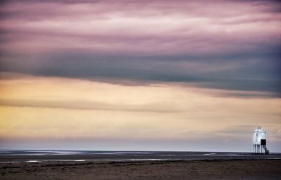 Scenic view of beach against cloudy sky