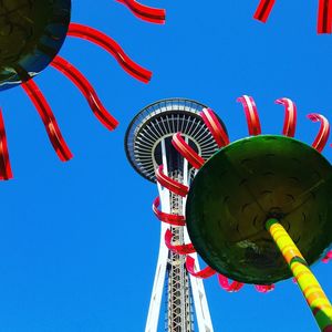 Low angle view of rollercoaster against clear blue sky