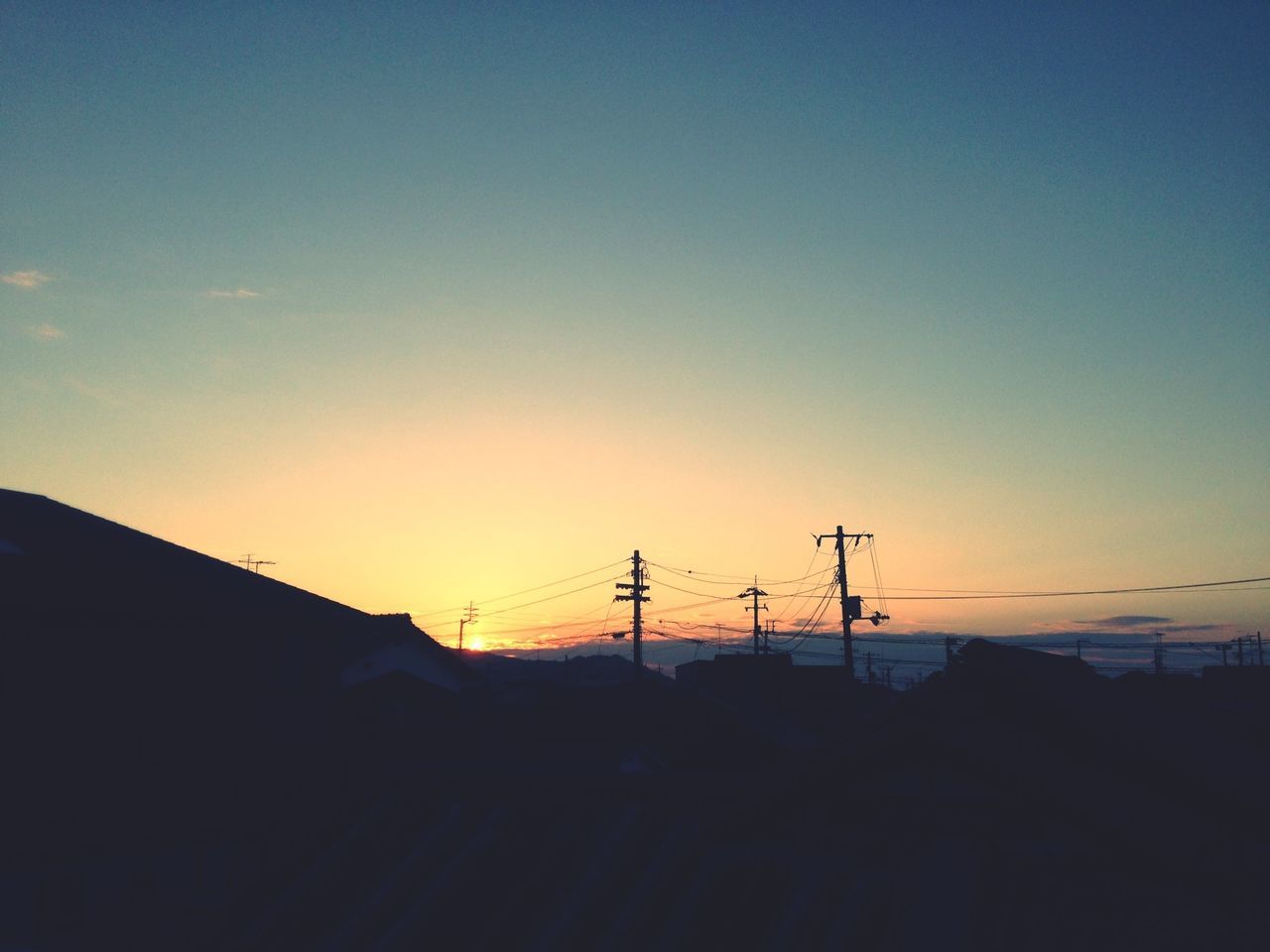 sunset, silhouette, copy space, electricity pylon, power line, built structure, clear sky, architecture, building exterior, electricity, fuel and power generation, power supply, connection, low angle view, orange color, cable, technology, house, sky, dusk