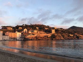 Scenic view of sea by buildings against sky