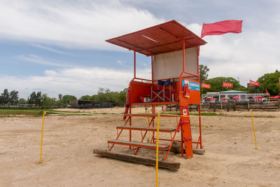 Lifeguard hut on field against sky