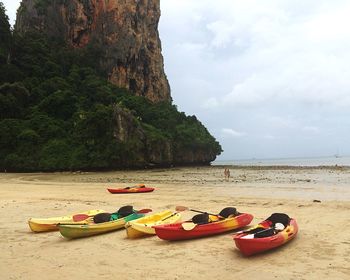 Kayaks moored at railay beach against sky