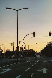 Street lights against sky at sunset