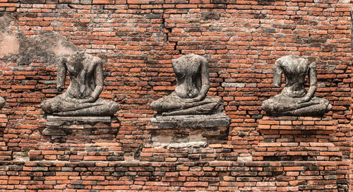 Statue against brick wall