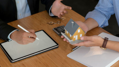 High angle view of people holding hands on table