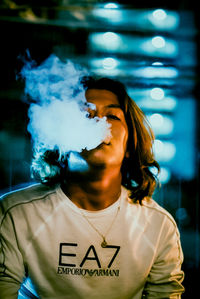 Portrait of young man smoking outdoors