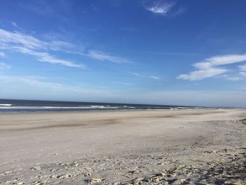 Scenic view of beach against blue sky