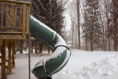 Snow covered field by trees in park