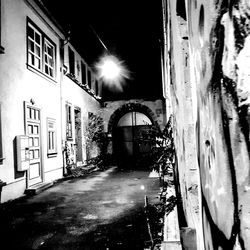 Illuminated street amidst buildings at night