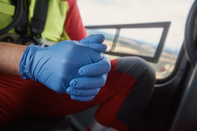 Close-up hands of doctor in surgical gloves inside helicopter of emergency medical service. 