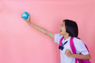 Happy asia young girl in unifrom with pink background.