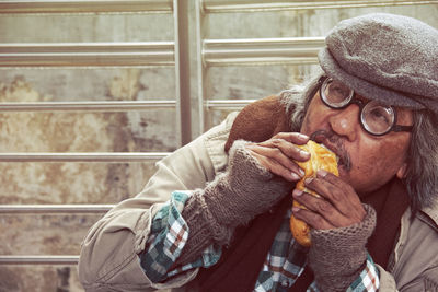 Man looking away while eating food